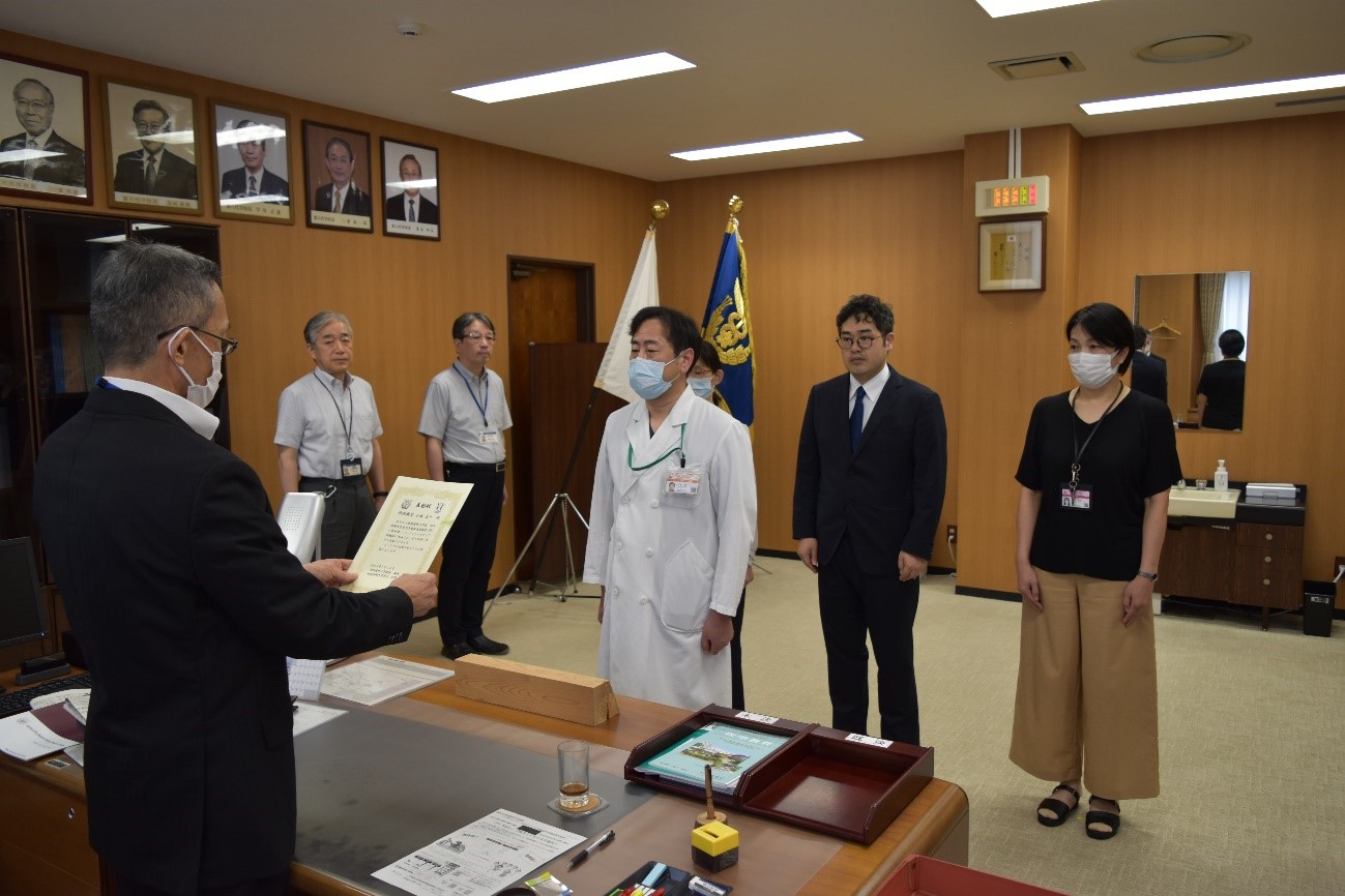 表彰状授与の場面 白衣姿の男性