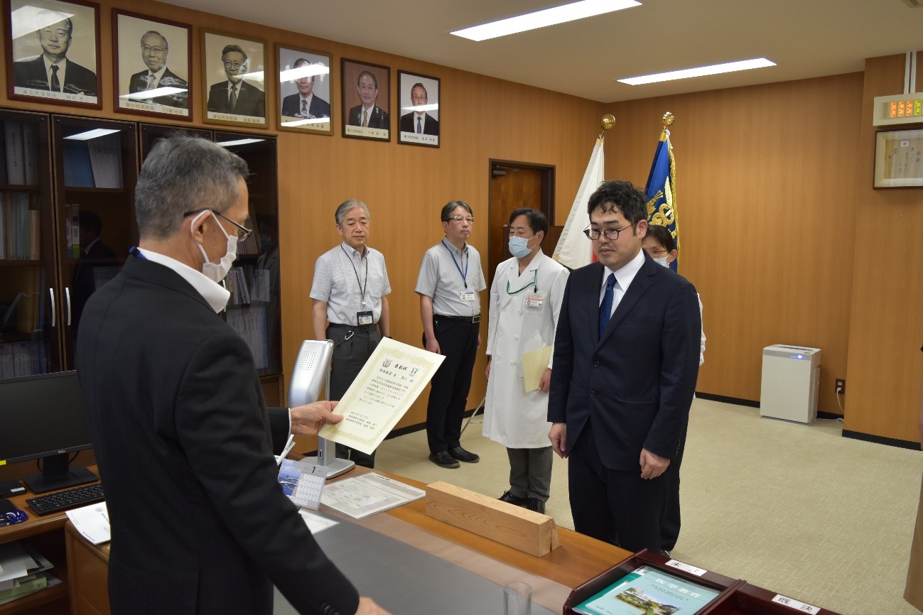 表彰状授与の場面 眼鏡をかけたスーツ姿の男性