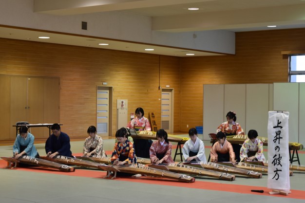 女子学生が着物姿で琴を弾く写真